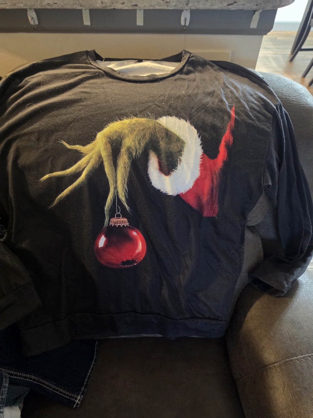 Black Crewneck Sweatshirt with Grinch-Inspired Graphic and Red Ornament